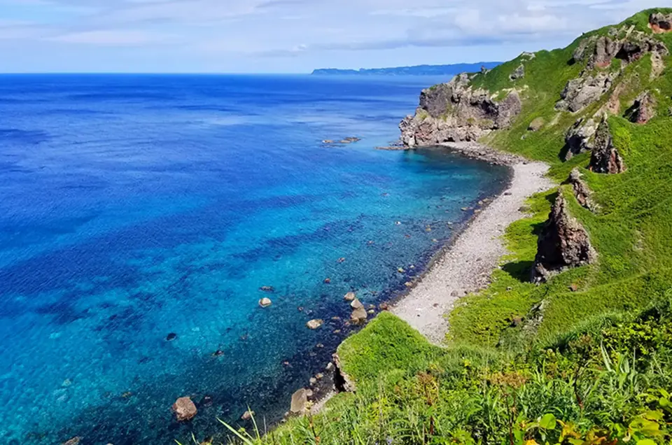 積丹半島の海岸。透き通ったターコイズの浅瀬から、深いコバルトブルーの日本海へ続いている
