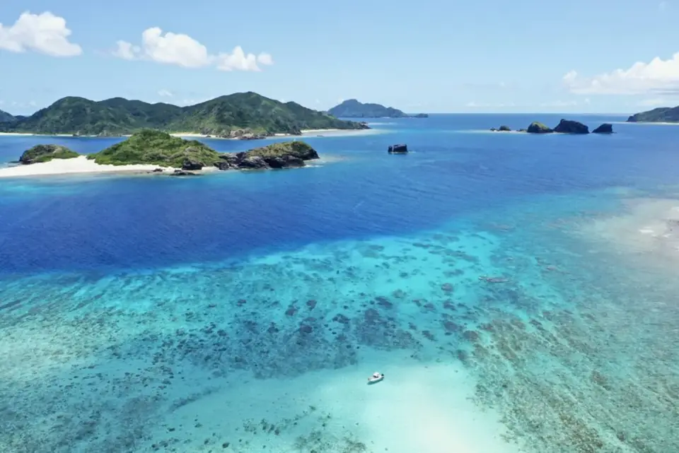 慶良間諸島の海。サンゴ礁の浅瀬から深い青へ、グラデーションが広がっている