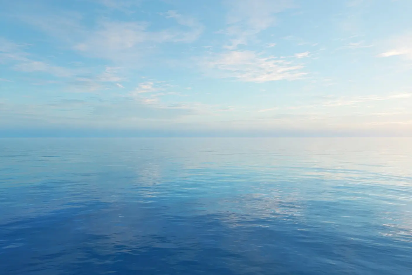 朝の静かな海と空。水平線で淡い水色の空と穏やかな青い海が溶け合っている